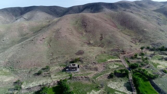 High quality aerial footage of fire temple area with visible pathways and arid hills extending to horizon.