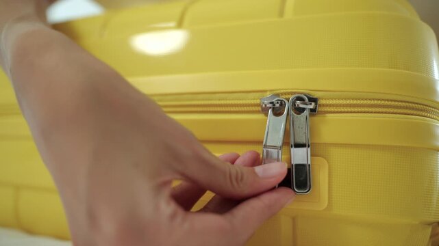 Close-up of a young woman zipping up a suitcase before a trip at home. Travel preparation, luggage organization, vacation planning, organized packing and smart travel lifestyle concept.

