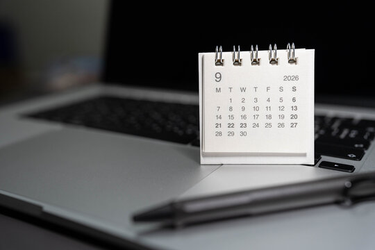 SEPTEMBER 2026 small desk calendar on laptop workspace with pen on office table. business scheduling, time management, event planning, deadline tracking, work efficiency, and corporate organizing.