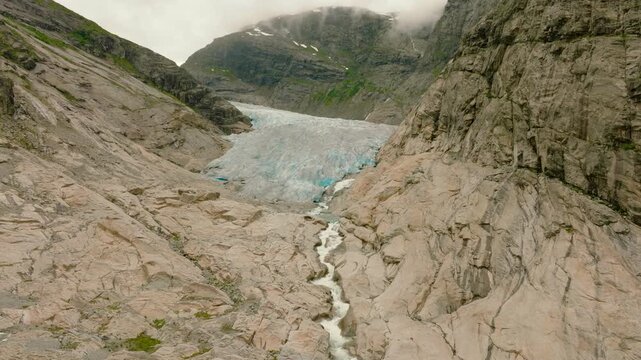 Aerial drone footage of the Nigardsbreen glacier, one of the glacier arms of the Jostedalsbreen ice cap in Norway. Various views show the blue-white glacier ice, crevasses, rocky surroundings and melt