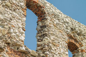 Stone castle wall with arched window against blue sky real detailed photography © Artem