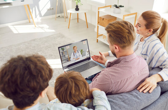 Young family with children listening recommendations and appointment having online video call with friendly smiling doctor using laptop at home. Telemedicine and patient consultation online concept.
