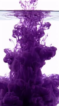 Purple Ink Dissolving in Clear Water Abstract - A vibrant purple ink cloud slowly dissolves and expands in clear water, creating an abstract, ethereal underwater effect.
