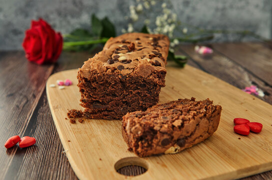 A cake on a wooden table with hearts and a rose. Soft focus concept
