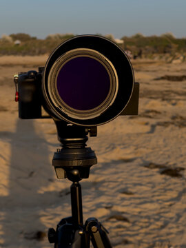 Saint-Come-De-Fresne, France - 08 10 2026: A camera mounted on a tripod to photograph the solar eclipse from a sandy beach.
