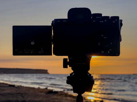 Saint-Come-De-Fresne, France - 08 10 2026: A camera mounted on a tripod to photograph the solar eclipse from a sandy beach.