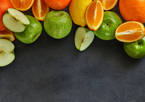 Healthy food background. The concept of healthy eating, fresh citrus and apples. On a black background. View from above. Copy s