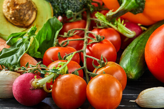 Healthy food background. The concept of healthy eating, fresh vegetables and fruits. On a black wooden background. Side view.