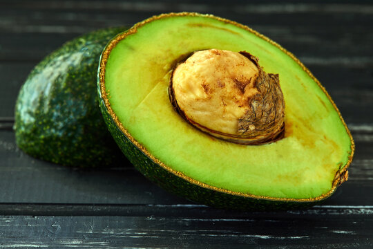 Healthy food background. Healthy food concept, fresh avocado. On a black wooden background. Side view. Selective focus
