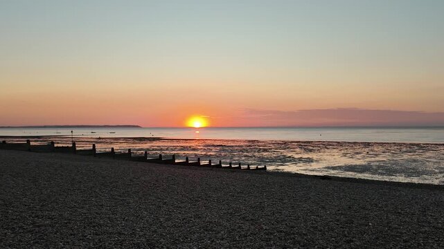 Summer evenings at Whitstable Beach, Kent - South East England, United Kingdom. 4K walking tour POV looking at the beautiful sunset on the horizon.