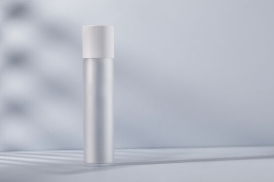 Sleek white cosmetic bottle bathed in gentle natural light. A pure, minimal design ideal for showcasing high-end skincare, facial serums, and luxury beauty products.