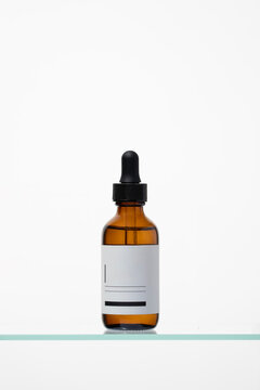 A clean amber glass dropper bottle with a blank label. Ideal for premium cosmetic, apothecary, or CBD oil packaging mockups against a white background