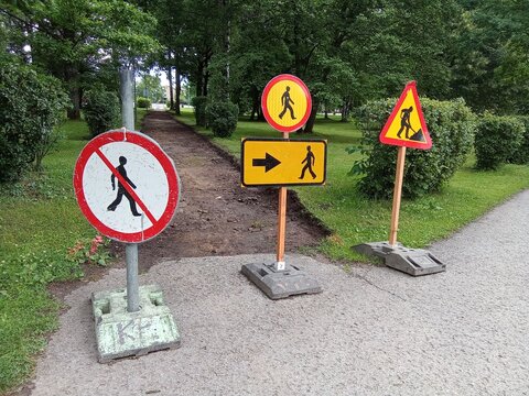 Temporary Pedestrian Detour and Roadwork Warning Signs in Green Public Park.

