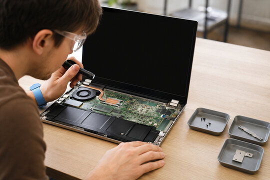 Technician Inspecting an Open Laptop for Refurbishment