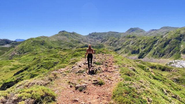 young woman walking on mountain trail trail ridge in summer landscape