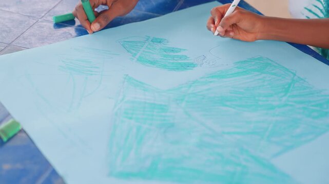 Guidance sparks artistic expression. Caregiving mother assists child in developing colorful paper shapes. Nurturing mother helps child craft lively drawings using bright hues and gentle guidance