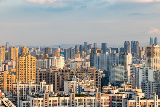 A sprawling urban skyline filled with numerous high-rise and mid-rise buildings under a pale sky, showcasing dense city development.