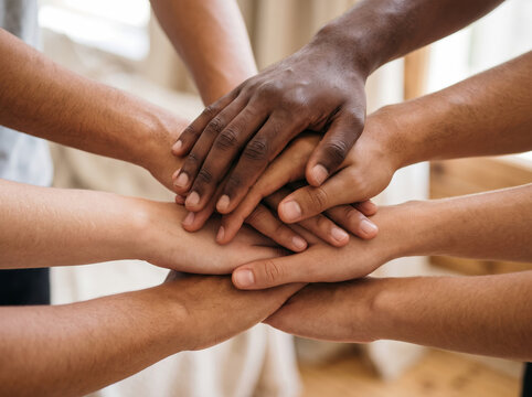 Diverse group of multiethnic people putting hands together in stack unity gesture