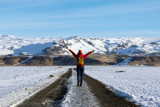 Asian woman in red  jacket running on dirt road in Landmannalaugar at highlands of iceland