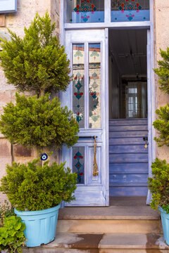 Traditional doorway on cunda island with colorful details and potted plants. Heritage, architecture and authentic lifestyle concept.