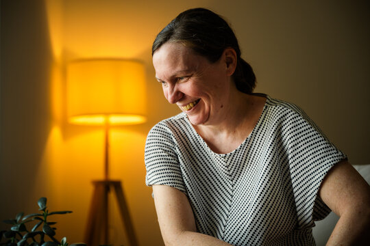 Mature woman looking away with a joyful smile after suddenly remembering something pleasant. Happiness, positive memories and emotional wellbeing concept.