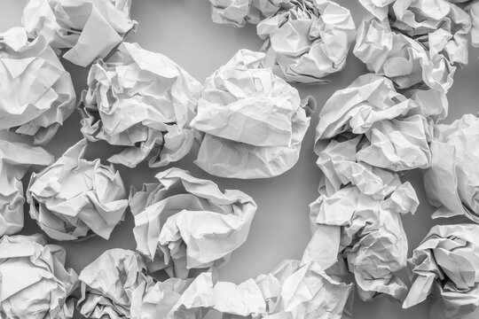 Crumpled White Paper Balls Scattered on Surface Concept