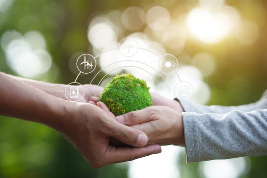 Hands Holding Green Earth with Renewable Energy Icons


