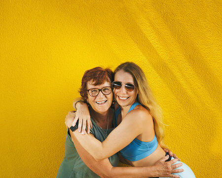 A happy woman and her adult daughter embracing with love and gratitude in summer &ndash; a Mother's Day portrait. Smiles and family happiness.