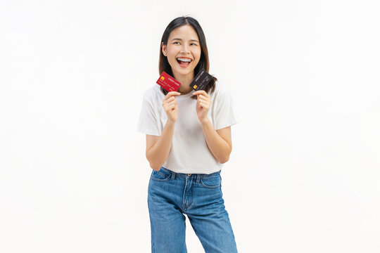 Happy young Asian woman holding credit cards with a confident smile isolated on white studio background.
