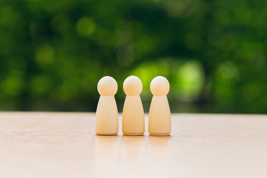 Wooden family figures on table with green background