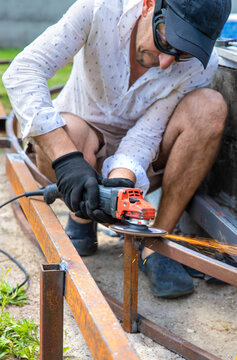 A man cutting metal with a grinder. Selective focus.
