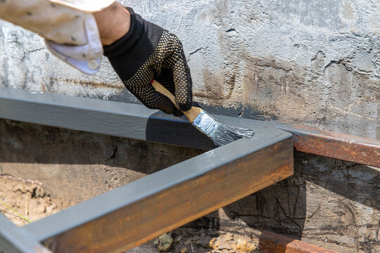 Man painting metal. Selective focus.