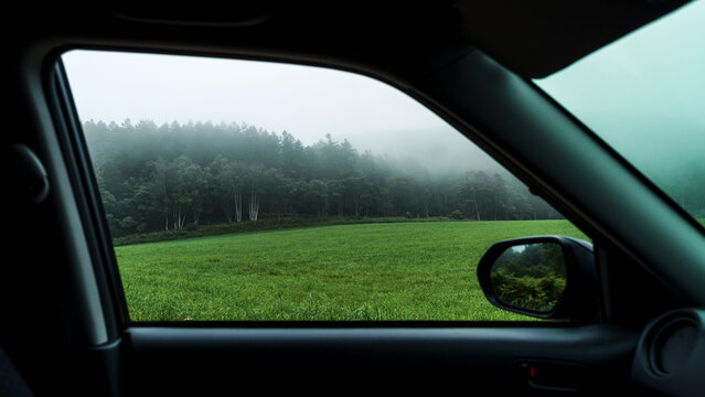 Foggy meadow seen through a car side window in Hokkaido