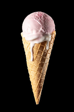 Pink strawberry ice cream scoop in waffle cone melting isolated on black background, vertical