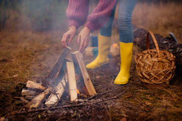 woman tourist making teepee fire in camping in autumn forest © cenchild