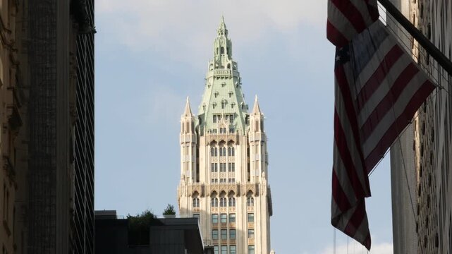 New York City Woolworth building 1913, skyscraper on Broadway in Downtown Financial District, Lower Manhattan, United States of America. Gothic historic architecture, cooper roof, USA american flag.