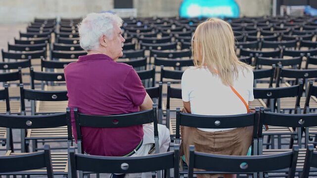 Portugal. Senior man and young woman having a conversation in an empty concert hall