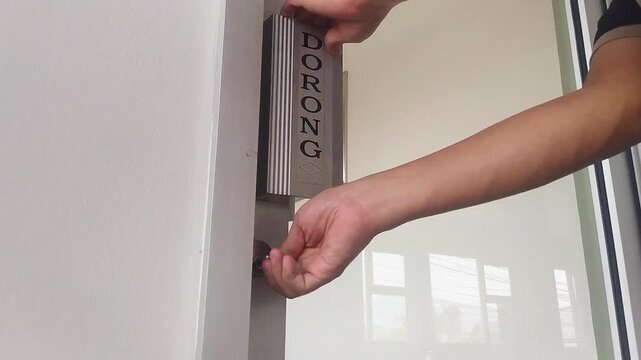 Close-up shot of a man unlocking and pushing open a glass entrance door featuring a push sign to enter an office or shop