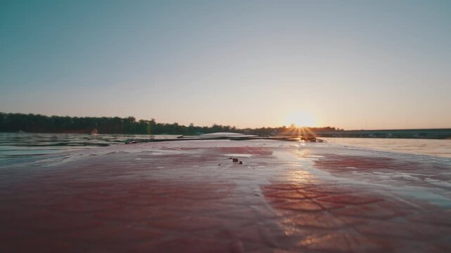 Paddle Blade Swinging Over SUP Board on Calm Lake at Sunset | Extreme Low Angle POV Shot with Sun Flare on Water Surface | Water Sport Motion
