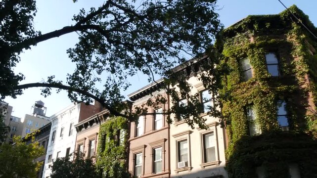 New York City townhouse buildings, brownstone row houses in Manhattan or Brooklyn, United States of America. Classic buildings on residential district street. Real estate property. Rowhouse townhome.