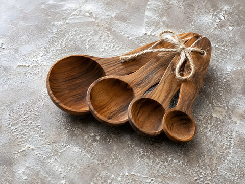 Wooden measuring spoons tied with twine on floured table