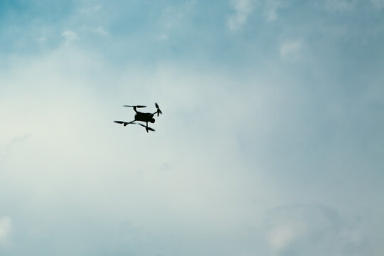 Drone flying in the blue sky with white clouds and copy space