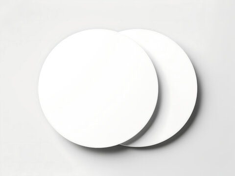 Two stacked blank round white coasters on light surface with coasters accessory minimalist tableware protection template presentation isolated