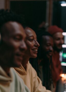 Group of four people, two men and two women, sitting in a dimly lit room. they are all smiling and appear to be enjoying each other's company.