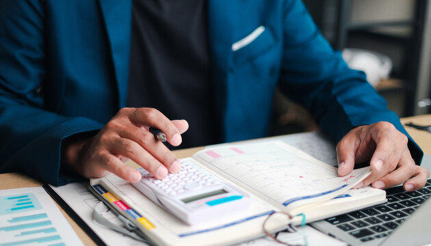 Business professional using a calculator and planner while working on a laptop, representing financial planning, budgeting, time management, productivity, accounting, and business strategy.