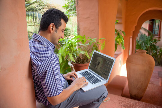 Man looking at pictures on laptop