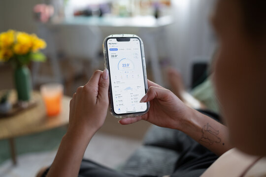 White Person adjusts temperature on smart home thermostat application