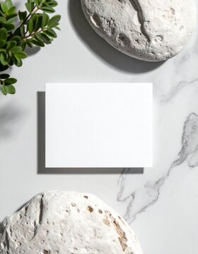 tarjeta de visita blanca en blanco sobre una superficie de piedra clara, composici&oacute;n minimalista