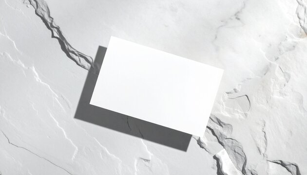 tarjeta de visita blanca en blanco sobre una superficie de piedra clara, composici&oacute;n minimalista
