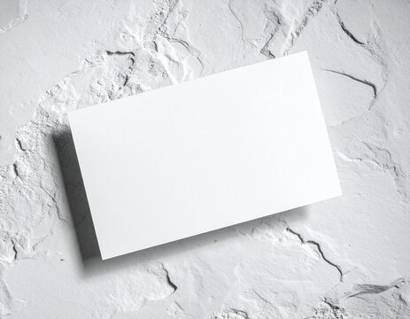 tarjeta de visita blanca en blanco sobre una superficie de piedra clara, composici&oacute;n minimalista